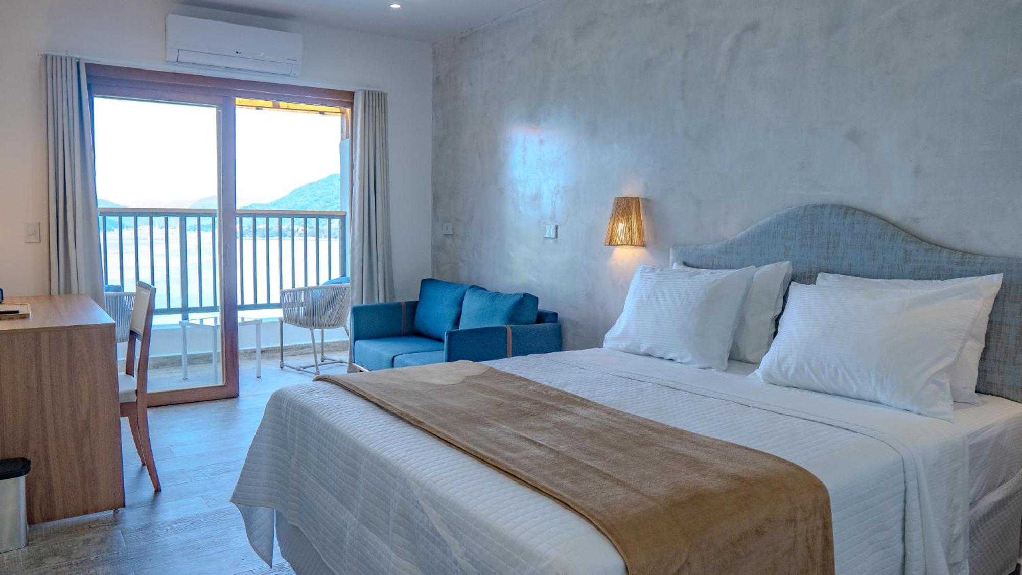Quarto com cama queen-size, varanda e vista do mar